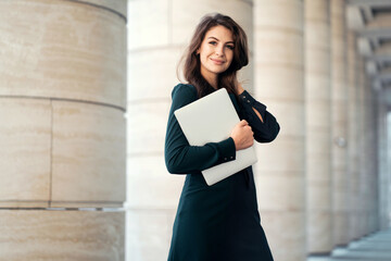 confident business woman brunette in a formal dress goes to work in the office in the bank