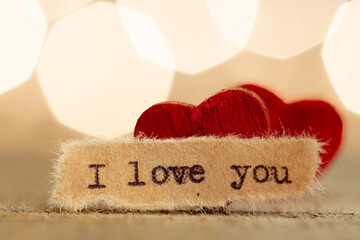 Valentine's Day greetings concept. Little red wooden heart and text I love you close up. Valentines greeting card.