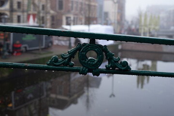 Raindrops on the green metal bridge fence
