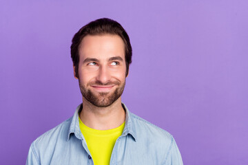 Photo of young funky smiling guy looking copyspace thinking evil plan tricky cunning isolated on...