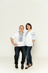 couple in national clothes on a white background. husband and wife in embroidered shirts. people of retirement age.