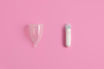 Tampons vs menstrual cup on pink background. Concept of alternative protection during critical days