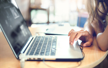 Focus on hand, Young asian woman using computer laptop working at home or cafe. concept people work or study online with new normal