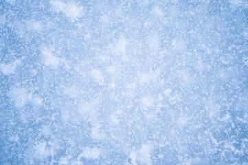 Obraz premium The texture of blue ice with white frost and reflected natural light. Background