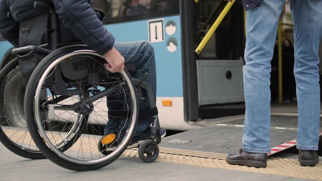 Person with a physical disability enters public transport with an accessible ramp