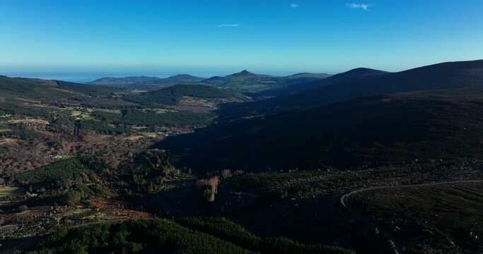 Wicklow Mountains, Ireland. January 2022 Drone gradually ascends while facing southeast towards Enniskerry with Bray and the Great Sugar Loaf in the distance.