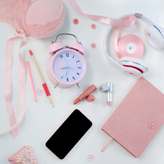 womens stylish accessories, smartphone with blank screen, glamorous set in pink shades, flat lay, copy background, womens clothing, alarm clock, lipstick, coffee cup, good morning concept, female life