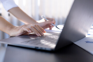 Fototapeta premium Businesswoman viewing financial data on laptop, she is reviewing financial data to bring to meetings with business partners. Concept of company financial management. Checking financial information.