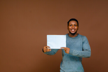 young smiling african man holding a blank sheet of paper for advertising - Powered by Adobe