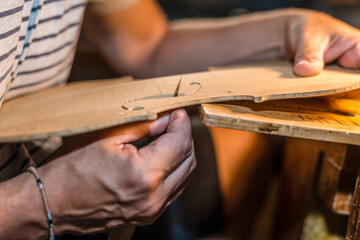 luthier violin maker working on a classic wooden hand made violin f holes in his workshop - obrazy, fototapety, plakaty
