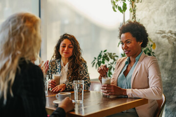 Three diverse women sitting at cafe