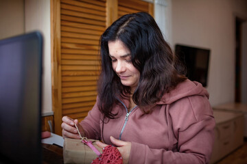 A woman opens a gift delivered to her online on Valentine Day and thanks her partner via internet, virtual communication and true love, social distance