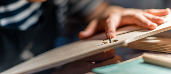 Luthier making a handmade classic italian violin, working  and carving  the f-hole and the top...