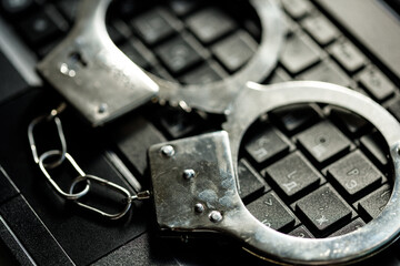 handcuffs on the laptop keyboard. hacker crimes