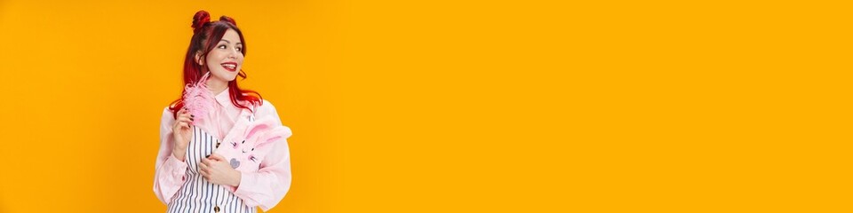 Joyful girl smiling while posing with stuffed diary and feather