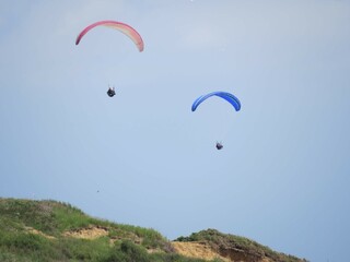 Fototapeta na wymiar paragliders going over the top of the cliffs
