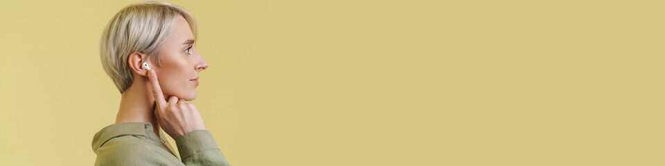 Pleased beautiful silver girl posing in wireless earphones