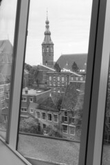 Black and white scenic view of Martini church from through windows of Forum building in the center of city of Groningen in The Netherlands