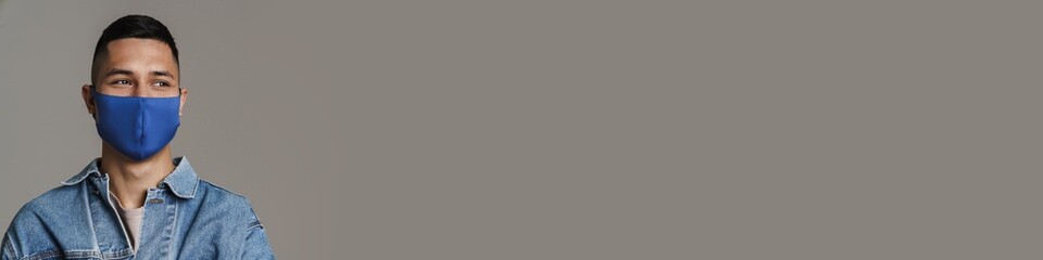 Happy caucasian guy posing in medicine protective mask