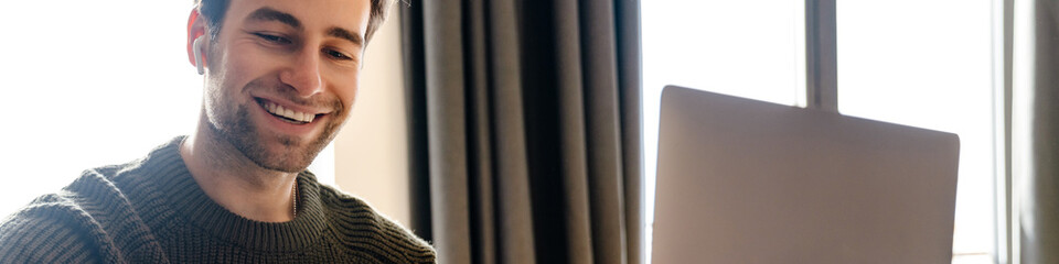 Mid aged man working on laptop computer from home