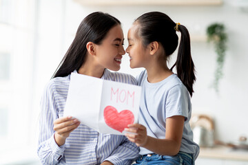 Family love. Happy asian girl hugging her mother and greeting with Mother's day, young woman holding handcraft present