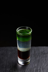 Alcoholic drinks at the bar. Bartender's hands in the process of making drinks.