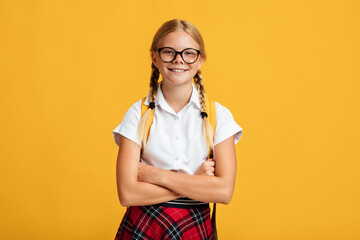 Glad smart confident cute european teen blonde female in glasses crossed arms on chest