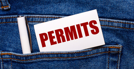 The back pocket of blue jeans contains a white pen and a white card with the text PERMITS