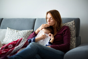 Young mother, holding her little sick boy