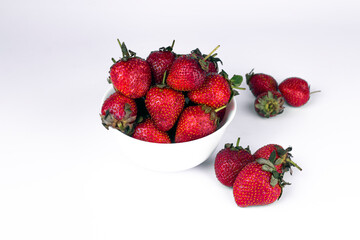 Fresh strawberry in white ceramic plate on white background.