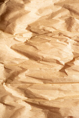 Texture of crumpled paper corrugated beige gold color closeup