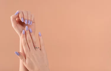 Zelfklevend Fotobehang Manicure Handen van een mooie goed verzorgde met vrouwelijke violette lavendelnagels gellak op een beige achtergrond. Manicure, pedicure schoonheidssalon concept.