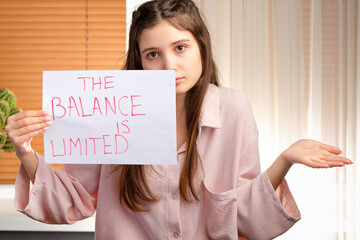 Close up photo of a young attractive woman holding a paper in her hands with an inscription and showing with her hand nothing to do.