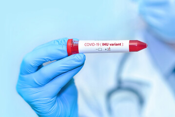 Doctor holding a test blood sample tube positive with IHU variant or strain COVID-19.