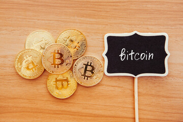 Golden Bitcoin coins and lettering on chalkboard, crypto currency concept and digital money	