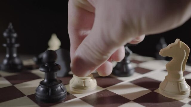 The king falls. Pawn knocking down the king in the game of chess. Concept for strategy and success. Close-up of player's hand.