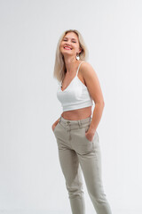 Beautiful blonde in jeans in the studio on a light background.