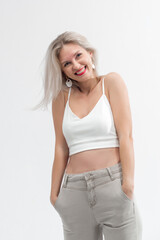 Naklejka premium Beautiful blonde in jeans in the studio on a light background.