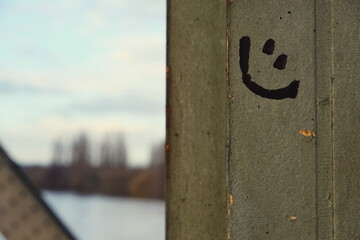 Lachender Smiley an einem Stahlpfeiler einer alten Eisenbahnbrücke