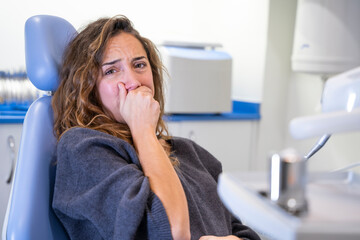 Young female patient in pain at the dental clinic