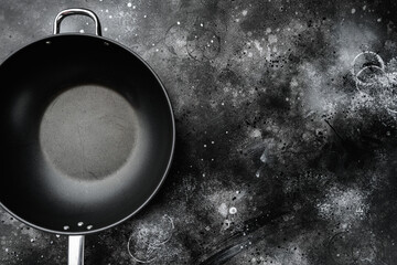 Empty Wok skillet with copy space for text or food with copy space for text or food, top view flat lay , on black dark stone table background