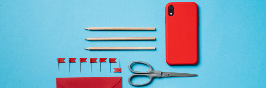 The Set Of A Phone, An Envelope, A Pencils And A Scotch Tape Lying In A Blue Studio