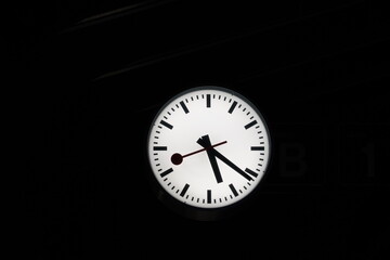 White clock on black background. There is a lot of copy space around. 