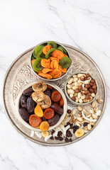 Mix of nuts and dried fruits on a table. Dates, apricots, kiwi, peaches, figs, cherries, banana, nuts, cranberries, pistachios