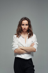 Confident pretty woman posing in black pants with a high waist and a white shirt. Business woman concept.