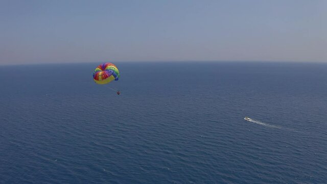 Parasailing. Aerial view of flying family with a parachute behind a boat. Extreme water sport and sea entertainment on the beach resort
