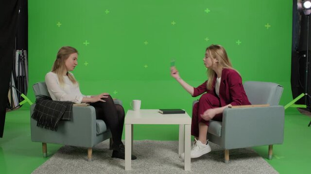 Young female patient and woman psychologist at psychotherapy session over green screen background. Youth talk show interview with a famous guest