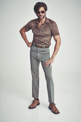 I'm kind of a big deal.... A handsome man in retro 70s clothing striking a pose in the studio.