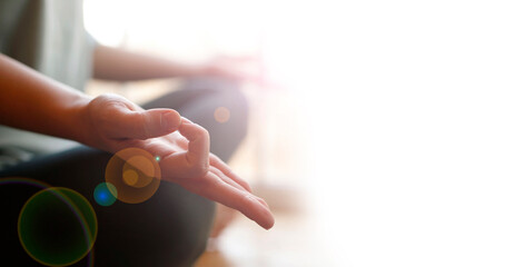 Close-up of woman's hand during meditation sitting on windowsill. Mental healthcare concept.