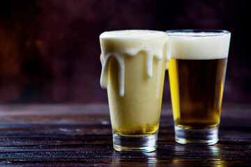 a large glass of cold light beer with foam on a dark background. St.Patrick 's Day